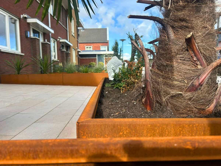 Close-up van cortenstalen plantenbakken in de voortuin