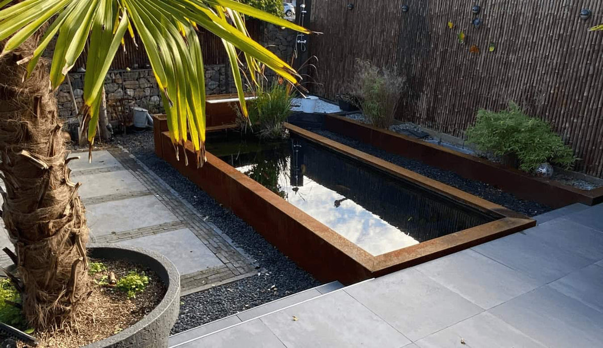 Cortenstaal vijverrand en plantenbakken op maat in een moderne tuin