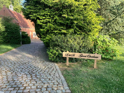 Metalen wandtekst met de initialen B B Groot Overlaar