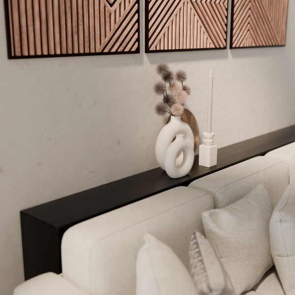 Zwarte metalen sidetable achter de bank, ideaal voor verlichting en stijlvolle accessoires