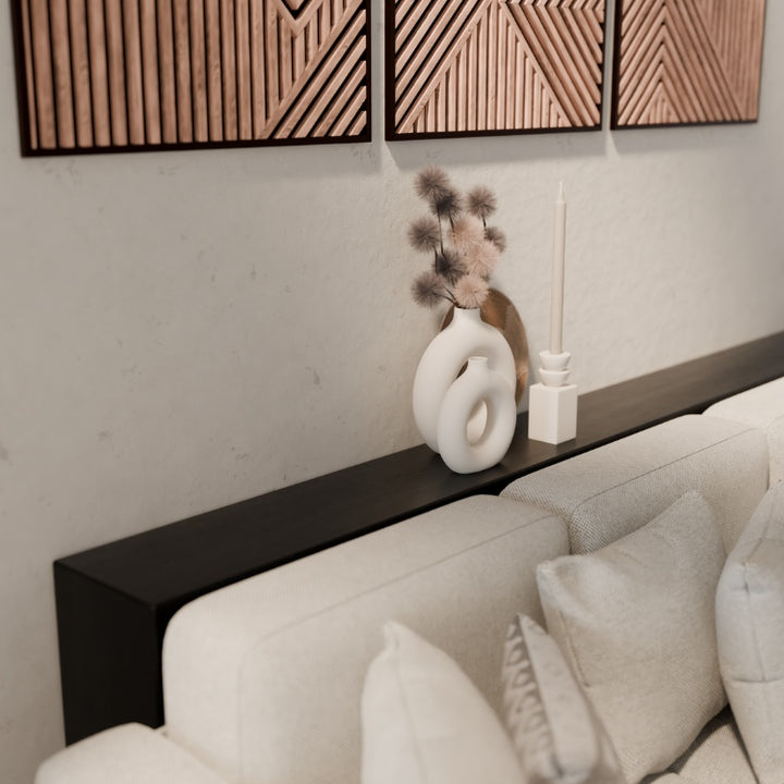 Zwarte metalen sidetable achter de bank, ideaal voor verlichting en stijlvolle accessoires