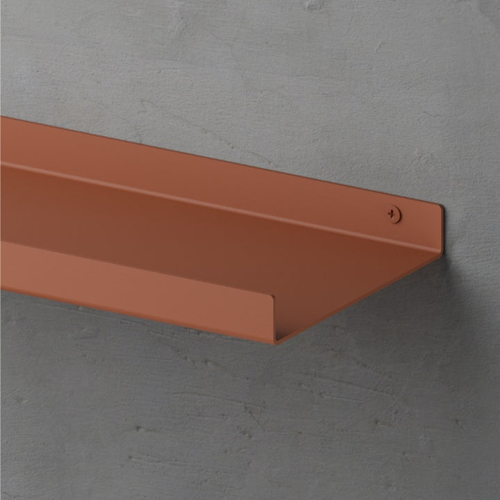 Donkerbruine metalen wandplank in een modern interieur, geschikt voor stijlvolle presentatie van accessoires