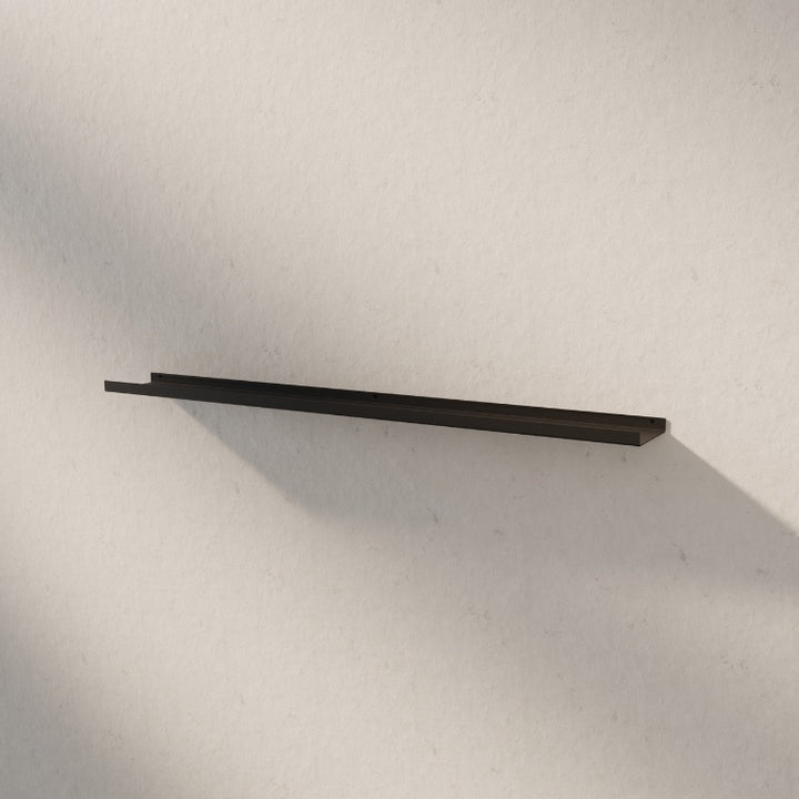 Lange metalen wandplank aan de muur gemonteerd voor extra opbergruimte